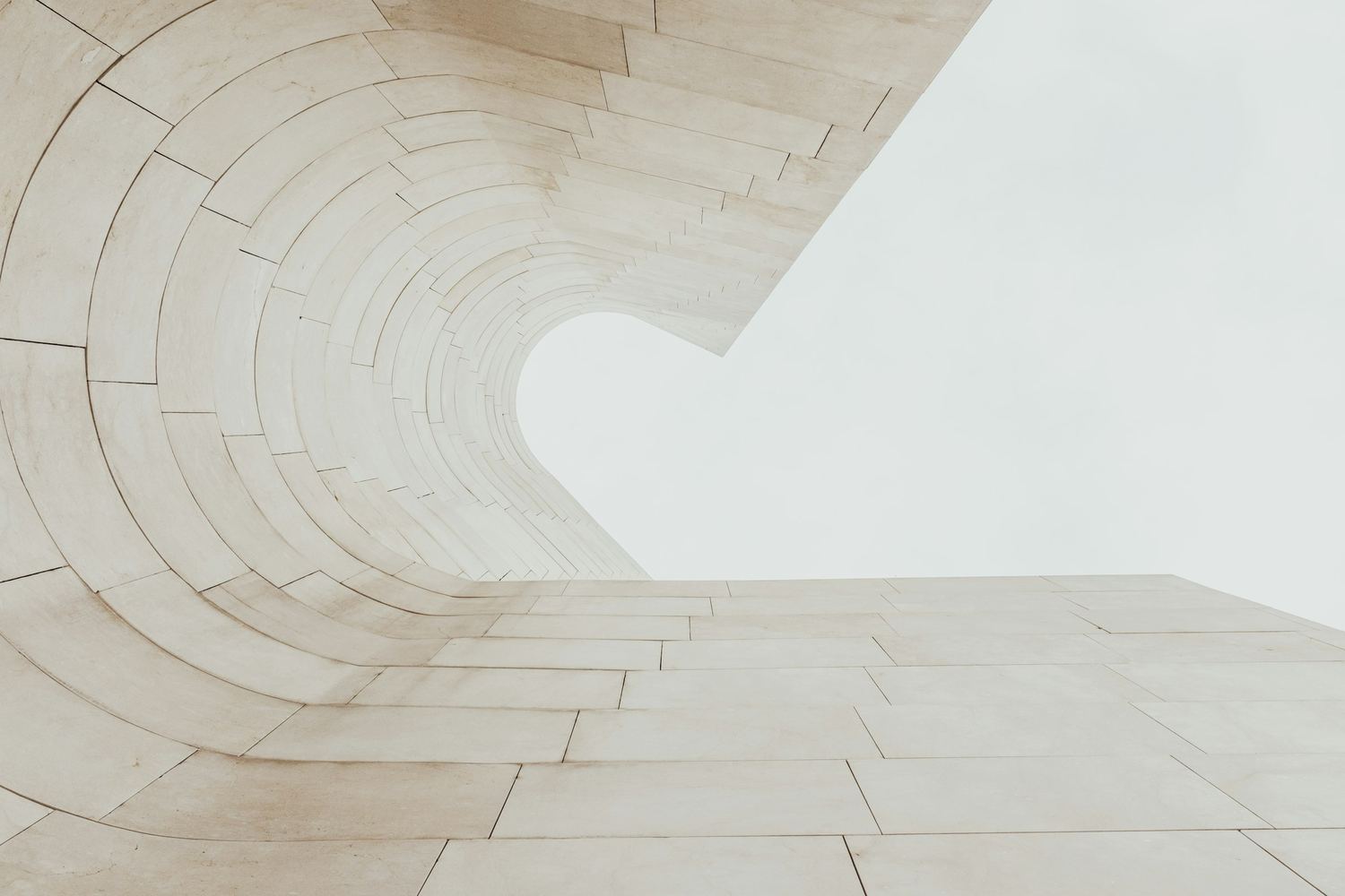The curve of a limestone facade narrowing towards an opening